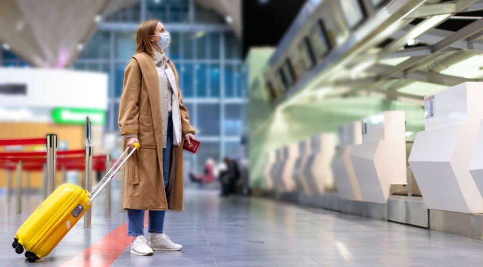 Toerist koffer mondkapje vliegveld liggend